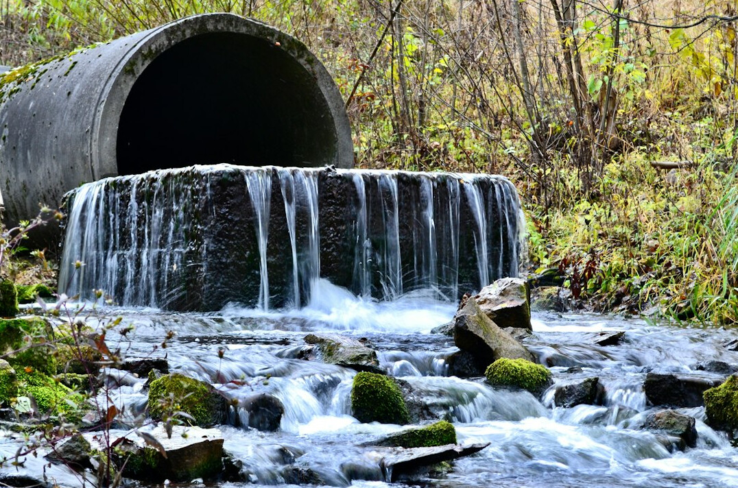 Industrial outflow pipe releasing water into a river